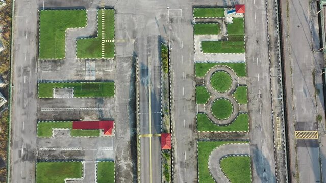 Vertical top down aerial view, drone flyover driving training course at perak malaysia with palm trees.