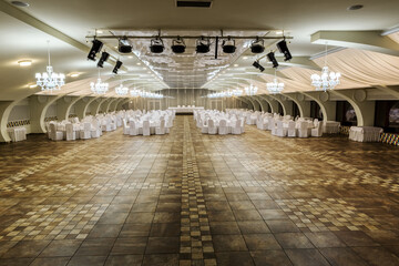 Banquet hall for wedding reception with served tables and spacious dance floor