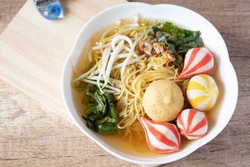 Egg noodles with Japanese colorful fish balls in a white cup