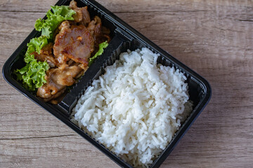Fried pork rice with steamed rice in a food delivery box