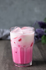 cold pink milk cold drink in clear glass on gray background. Thai milk