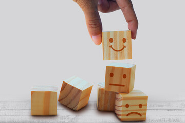 Wooden blocks hand flipping wooden with emoji icons isolated on a white background.