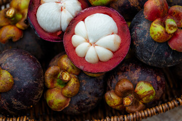 Naklejka na ściany i meble Fresh mangosteen in a wicker basket on the back of natural green color.