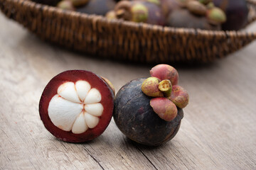 Fresh mangosteen in a wicker basket on the back of natural green color.