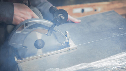  carpenter cuts a wooden panel with a power tool