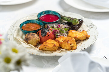 Shish kebab and vegetables, chicken with sauce. Photo of food on a dark background
