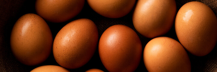 Red hen eggs on dark rustic table, organic food ingredients
