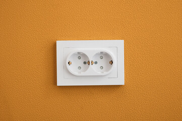 Electrical outlet close up in the yellow wall background
