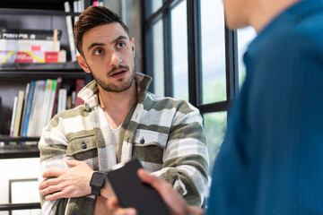 Caucasian male creative designer talking with colleague in the office studio. Man in casual cloth discussing work project while take a break.