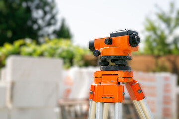Surveyor equipment tacheometer or theodolite outdoors at construction site. Copy space. Close-up. Orange color. Geodetic tool. Contractor does examination the building object with measurement device