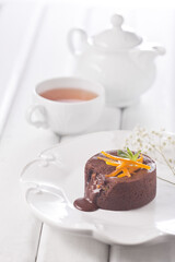 Chocolate fountain, orange cupcake. Photo of food on a dark background