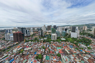 Cebu City, Philippines - Contrast of incomes, modern office buildings loom over a crowded poorer...
