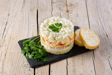 Traditional Russian layered salad Mimosa on wooden table