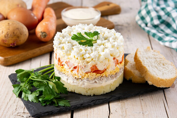 Traditional Russian layered salad Mimosa on wooden table