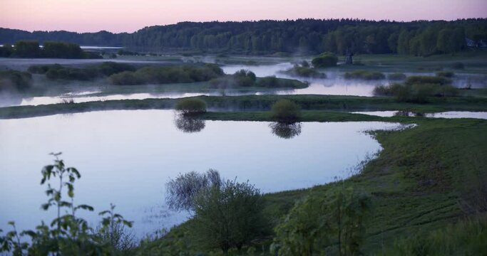 morning, winding river from which steam, fog, dawn time emanate, mill in the distance