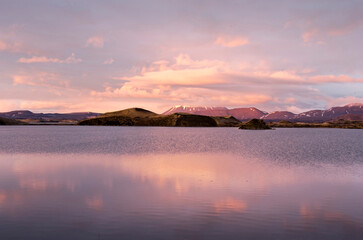 Landscape with mountains, hills and craters under a spectacular sky reflecting in lake Myvatn, Iceland