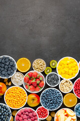 Berries, fruits and nuts on a black concrete background. Vegetarian food. Copy space