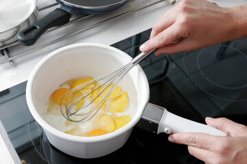 Mano batiendo huevos con una varilla. Hand beating eggs with a rod. - obrazy, fototapety, plakaty