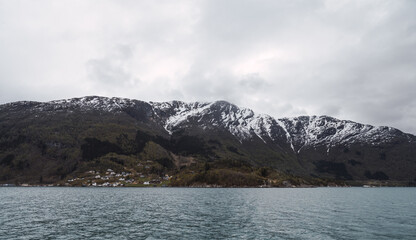 view of a snow mountain at fjord level in Norway.