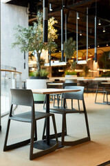 Fototapeta na wymiar Vertical background image of table and chairs set in loft style food court interior