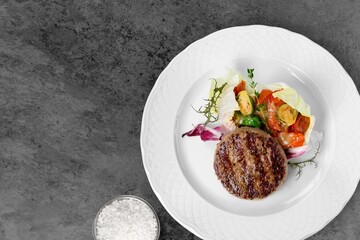 Roast barbecue sliced on white plate. Beef veal steak with vegetable on a plate. Top view.