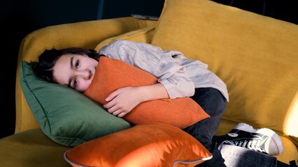 Frustrated introvert girl aged 13 lies on the couch at home and suffers from school discrimination...
