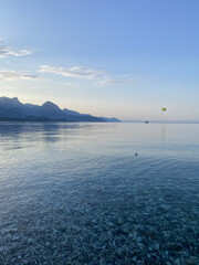 Pebbles on the seashore, sea background. A sea wave washes a pebble beach. View beach on the coast of Mediterranean sea in Kemer district of Antalya Province, Turkey