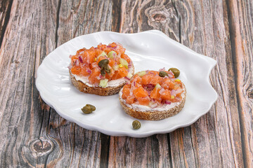 Salmon tartar over bread served capers