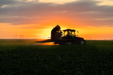 Tractor spraying soybean crops field