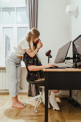 Girl covering her boyfriend's eyes and surprising him while he playing video game