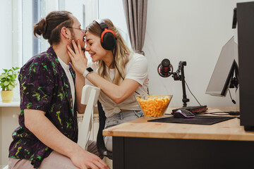 Young couple relaxing and showing love while playing video games on a personal computer