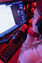 Woman blogger using condenser microphone during online podcast in room with neon light © blackday
