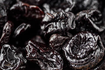 delicious dried prunes on a white acrylic background