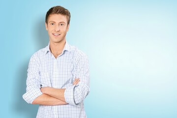 Smiling young businessman in black suit on pastel background