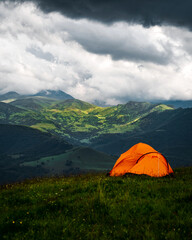 Camping in the mountains with tent standing on a hill, night and sunset landscape © SDF_QWE