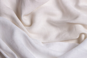 White crumpled linen fabric texture background. Natural linen organic eco textiles canvas background. Two shades of white color linen cloth material. Top view, copy space