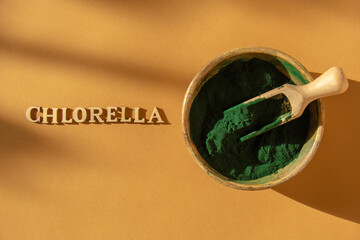 Blue-green algae with message CHLORELLA and spirulina powder in bamboo eco bowl, dietary supplement...