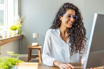 Shot of a young businesswoman working on a computer in an office. Portrait of an successful young creative businesswoman using PC at her workplace in the modern office