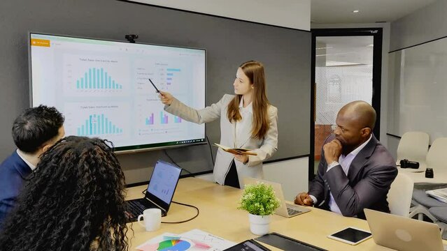 woman leader guide team building training on informal meeting at boardroom. Young female mentor discuss marketing report with intern group propose plan to increase sales to multiethnic staff 