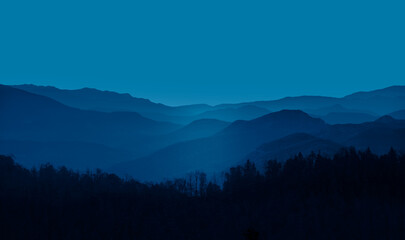 Beautiful landscape with blue misty silhouettes of mountains 