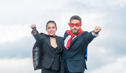 smiling business couple in superhero suit on sky background © Olena