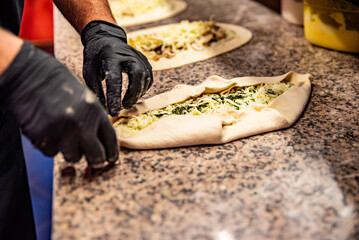 chef hand cookind pide on kitchen table