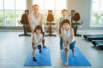 Family having fun together and doing sport yoga in the fitness room, Family morning exercise.
