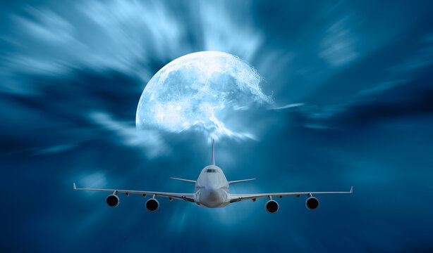 Passenger airplane in the sky and full moon at sunset in the background "Elements of this image furnished by NASA"