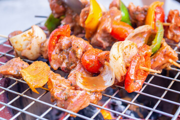 Barbecue skewers meat with vegetables on grill close up