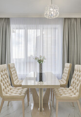 Dining table with two chairs, a place for a picture and sunshine in the kitchen