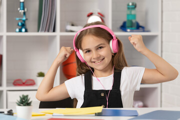 happy kid listen to music in headphones at school classroom. happiness