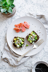 Healthy breakfast with salmon and toasts with rye bread, avocado and blue cheese