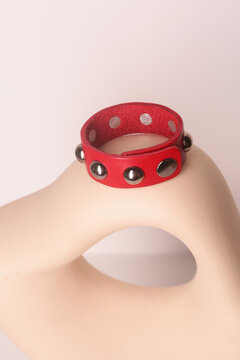 leather studded red bracelet close up photo on white wall background