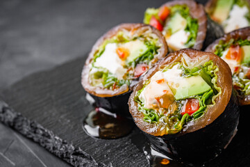 delicious sushi rolls on a black stone background